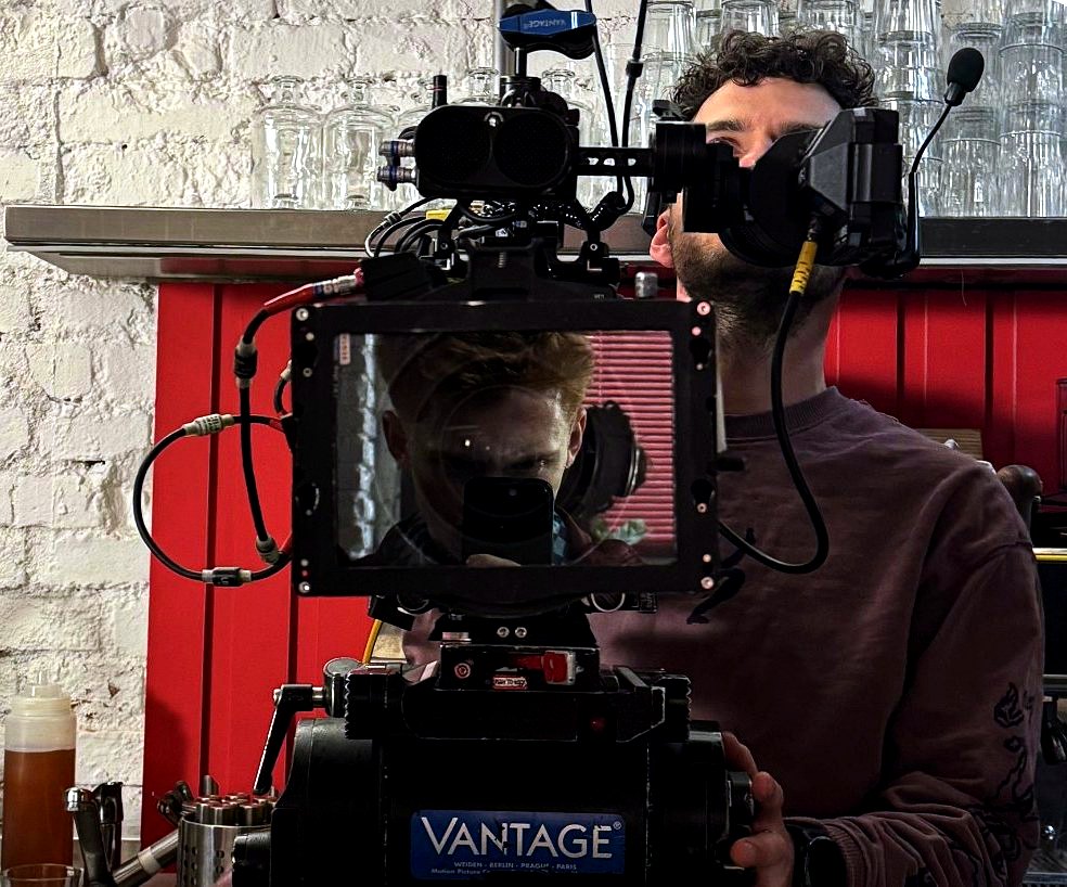 Václav looking through a cinema camera on set