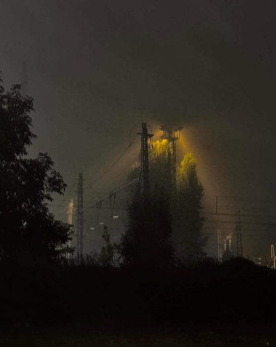Fog and a yellow streetlight over the railway