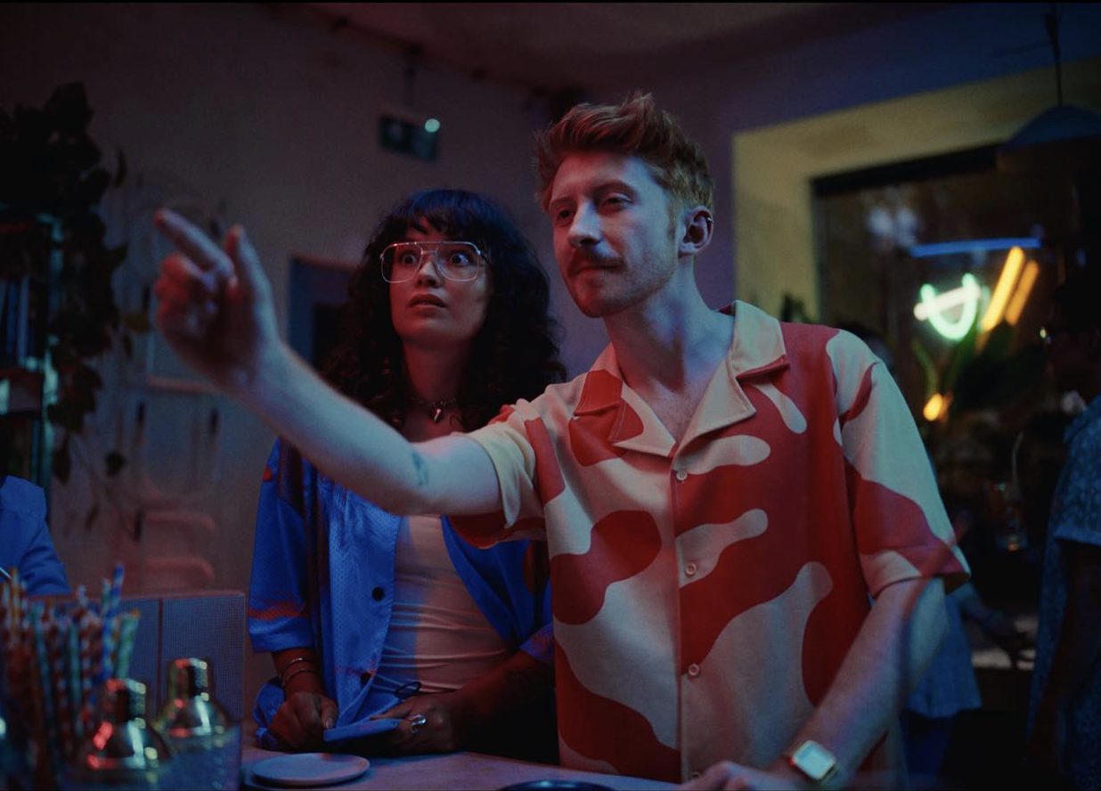 Still from the Česká spořitelna ad: Václav at a bar in a red patterned shirt